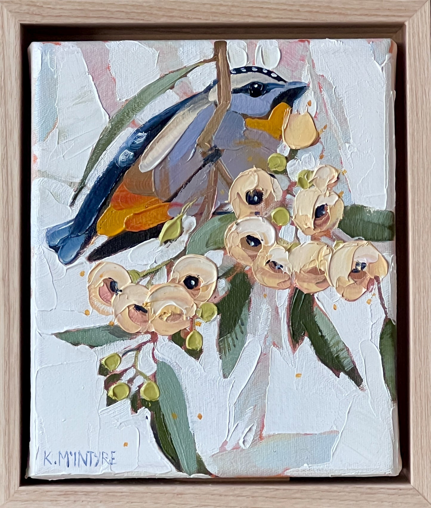 Painting of a bird perched on a branch with flowers, signed K. Mcintyre, in a wooden frame. spotted pardalote