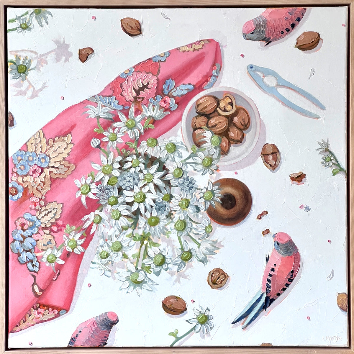 A square still life painting featuring a pink floral scarf, white daisy-like  flannel flowers, walnuts, a blue nutcracker, and pink birds on a white background, framed by a thin brown border. Australian birds and flowers