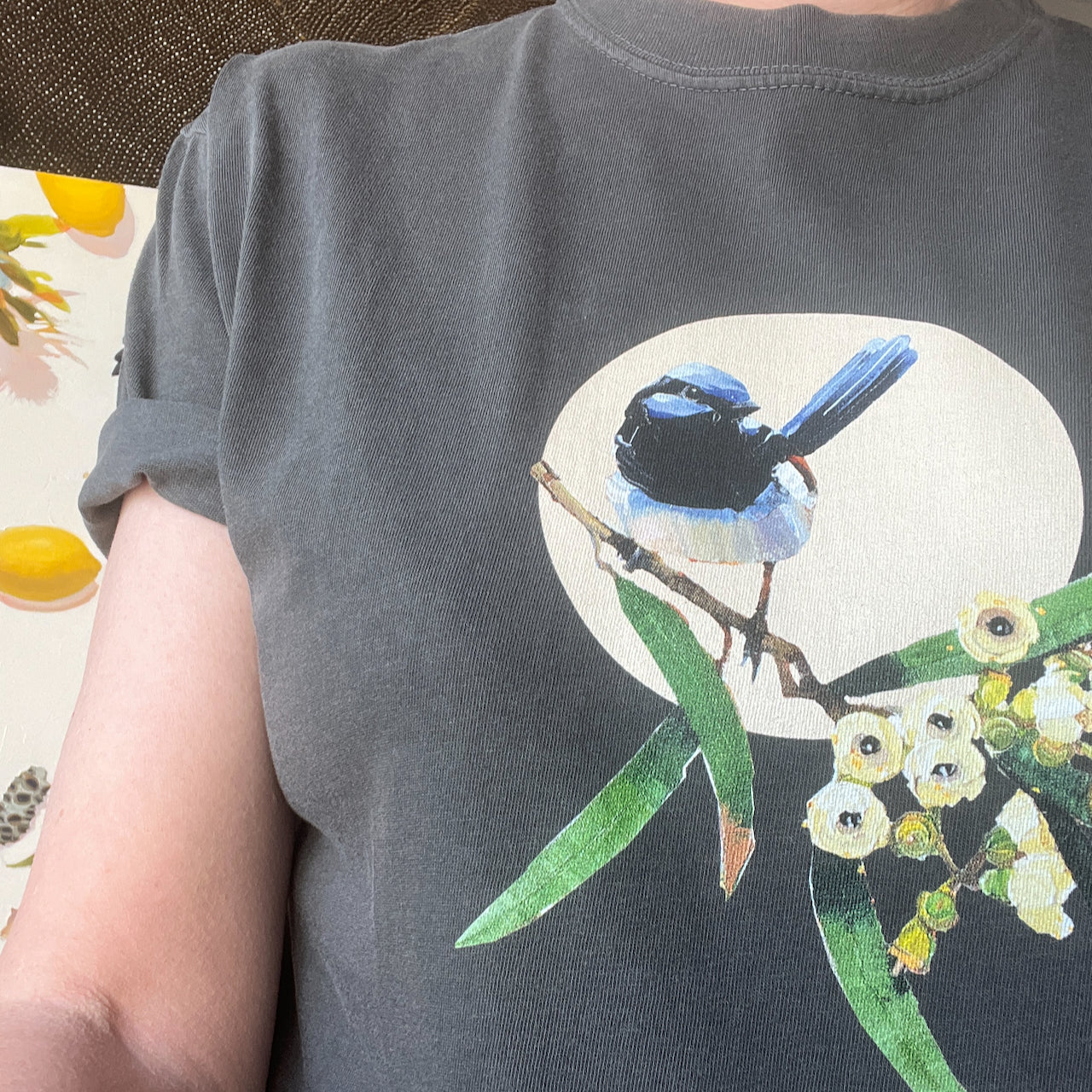 Person wearing a t-shirt with a bird and floral design on a neutral backgroundcomfort colours tshirt with an "Every day is wrensday" original art design by kirsty mcintyre art with a blue wren and gum blossom