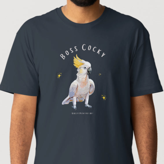 Person wearing a navy blue t-shirt with a parrot graphic and text 'Boss Cocky' on a white background. Original cockatoo tshirt design by artist, Kirsty McIntyre, australian.