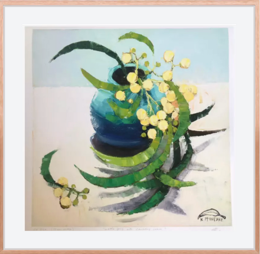 Framed artwork of a blue vase with yellow flowers and green leaves on a light background- wattle sprig with cascading leaves giclee print reproduction art by Kirsty McIntyre, Australian artist